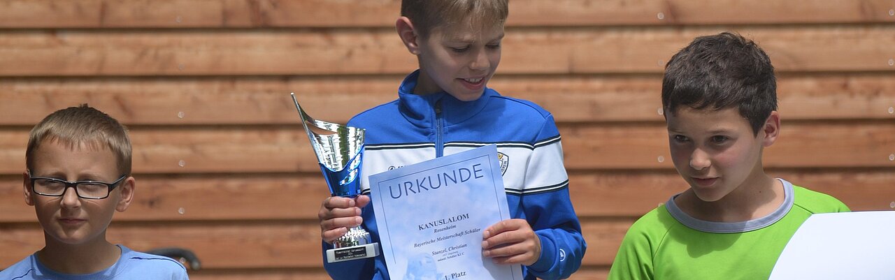 Klein Christian mit Pokal und Urkunde auf dem Siegertreppchen in Rosenheim 2017