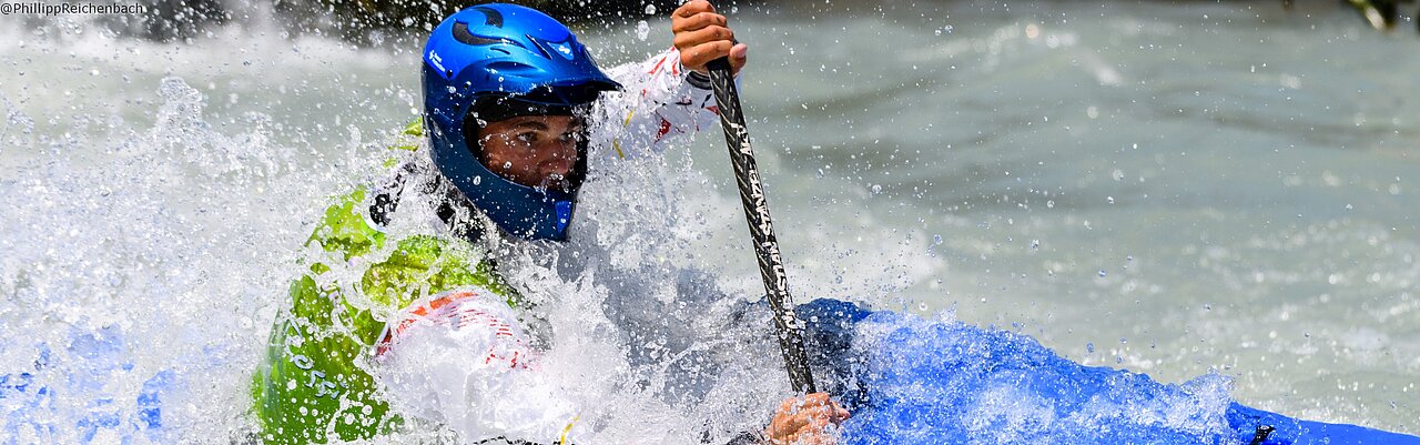 Christian Stanzel im blauen Kayak Cross Boat mit Vollschutzhelm